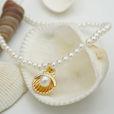 Golden shell and pearl necklace with a delicate gold-toned shell pendant and lustrous white pearls